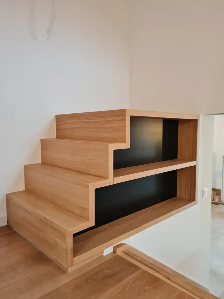 Escalier en bois avec rangement intégré design moderne Escalier moderne en bois clair avec étagères de rangement intégrées et fond noir sur le côté.