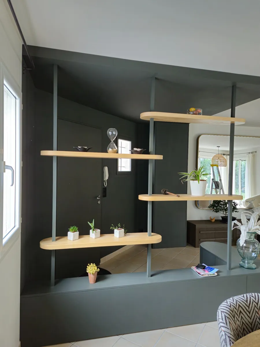 Perspective de profil d’un agencement intérieur ouvert, montrant une séparation fonctionnelle et design entre l’entrée et le salon.