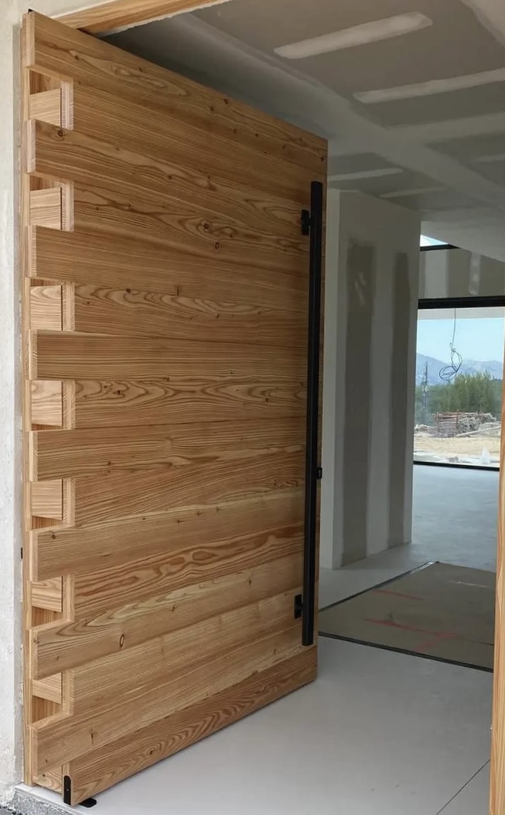 Création d'une porte d'entrée en bois de mélèze sur pivot invisible