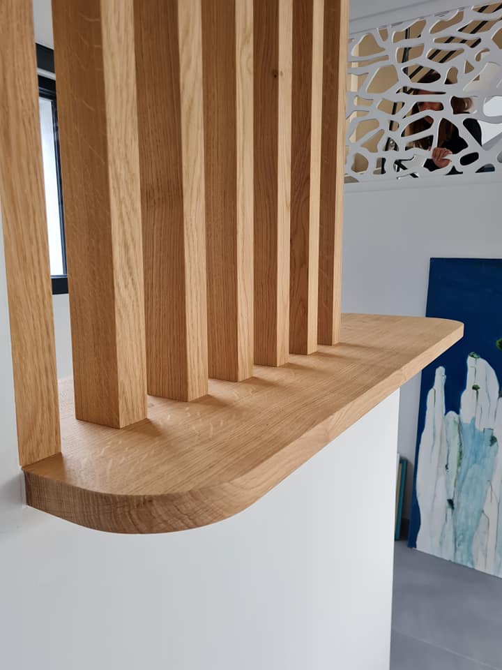 Claustra en chêne sur mesure avec tablettes et suspentes intégrées entre un bureau et un salon à Villefranche-sur-Mer